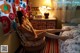 A woman sitting on a chair in a bedroom.