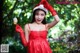 A woman in a red dress holding a lollipop.