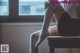 A woman sitting on a desk with her legs crossed.